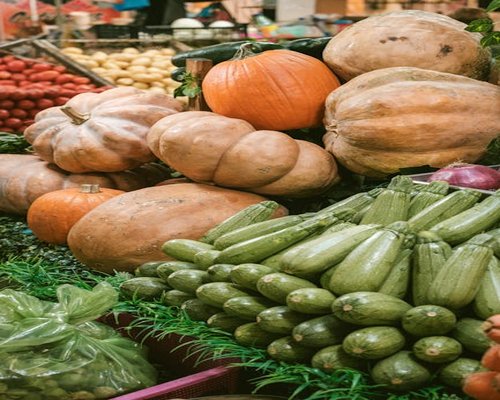 Assorted colorful seasonal vegetables like squash, zucchini and tomatoes at a traditional Mexican market counter