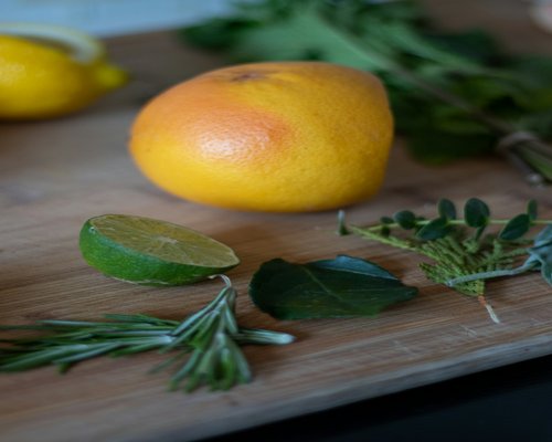 Fresh fish fillet prepared alongside local citrus and standard healthy herbs on a cutting board