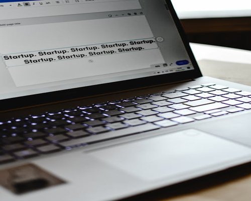 A laptop screen showing clean modern text documents set up with soft light backgrounds in an office setting